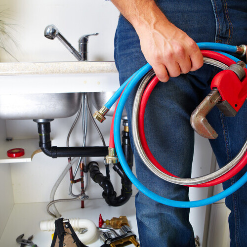 plumber with a variety of plumbing tools and equipment