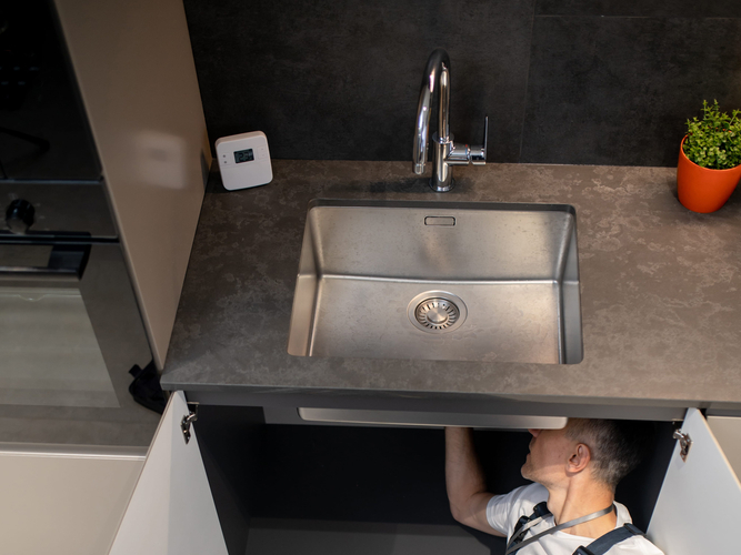 Man lying down fixing breakdown of sink