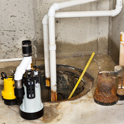Replacing the old sump pump in a basement with a new one to drain the collected ground water from the sump or pit